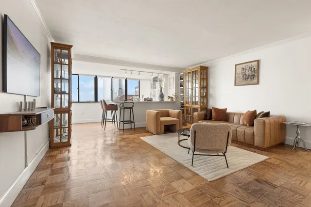 a living room with furniture and a view of kitchen