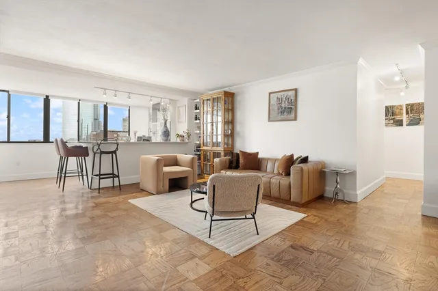 a living room with furniture and a view of kitchen