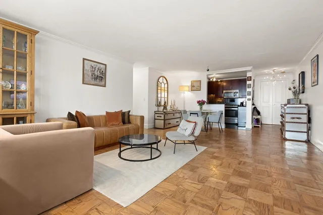 a living room with furniture kitchen view and a window