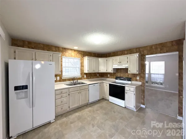 a kitchen with stainless steel appliances granite countertop a refrigerator and a stove top oven
