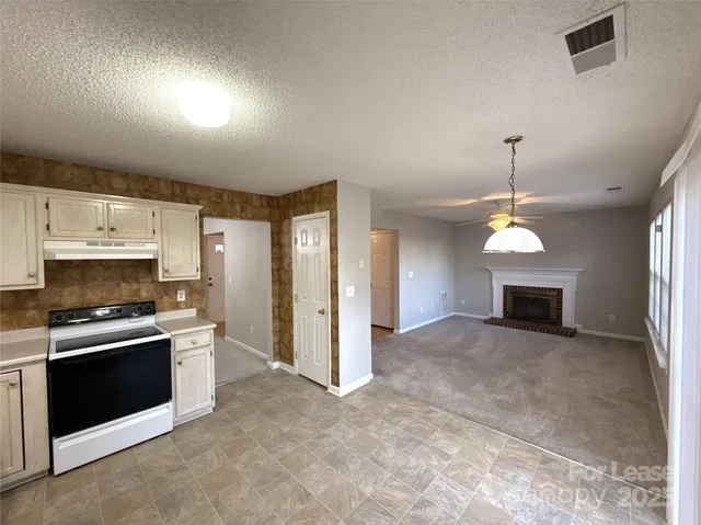 a view of a kitchen with a sink and a fireplace