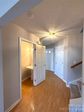 a view of a room with wooden floor and a bathroom
