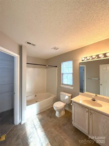 a spacious bathroom with a bathtub shower sink mirror vanity and a toilet