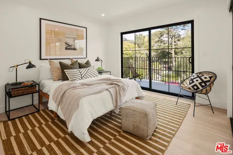 a bedroom with a bed and a large window