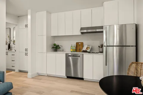 a kitchen with a refrigerator and white cabinets