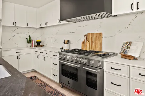 a kitchen with white cabinets and appliances