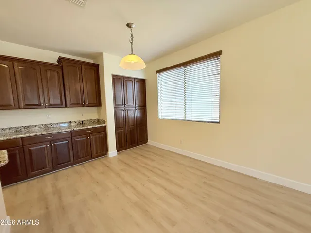 a kitchen with stainless steel appliances granite countertop a refrigerator a sink dishwasher a stove and a oven with wooden floor