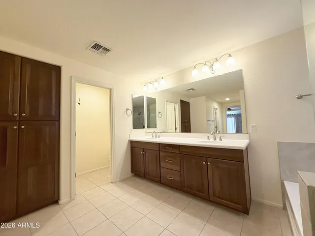 a spacious bathroom with a double vanity sink and a mirror