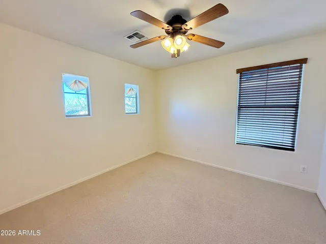 an empty room with closet and a chandelier fan