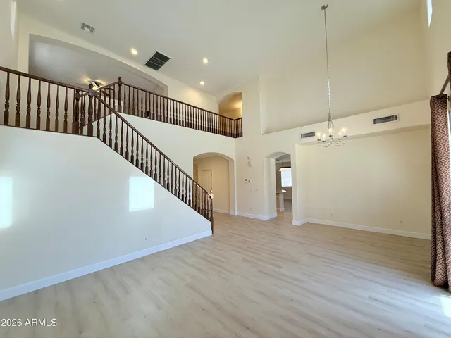 a view of a hallway with wooden floor and stairs