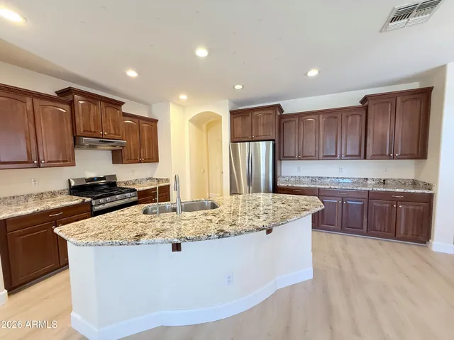 a kitchen with kitchen island granite countertop a stove sink and cabinets