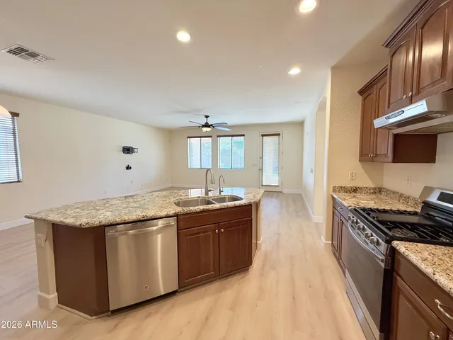 a kitchen with granite countertop a sink and a stove top oven