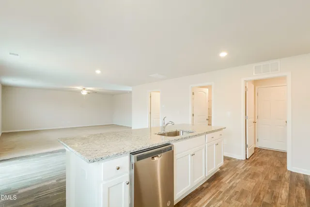 a view of a kitchen island a sink and dishwasher with wooden floor