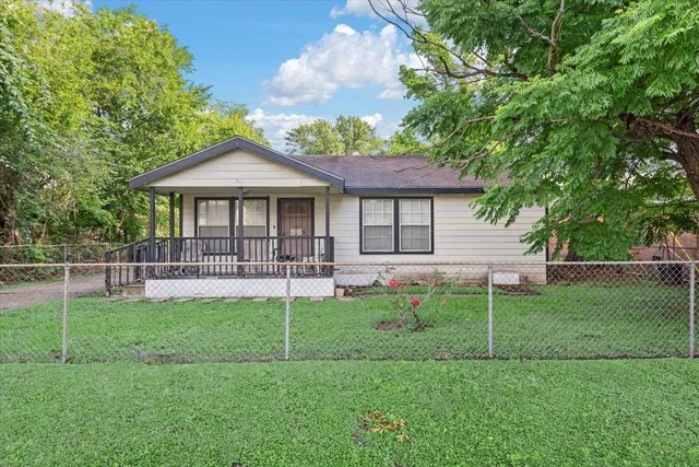a front view of a house with backyard and porch