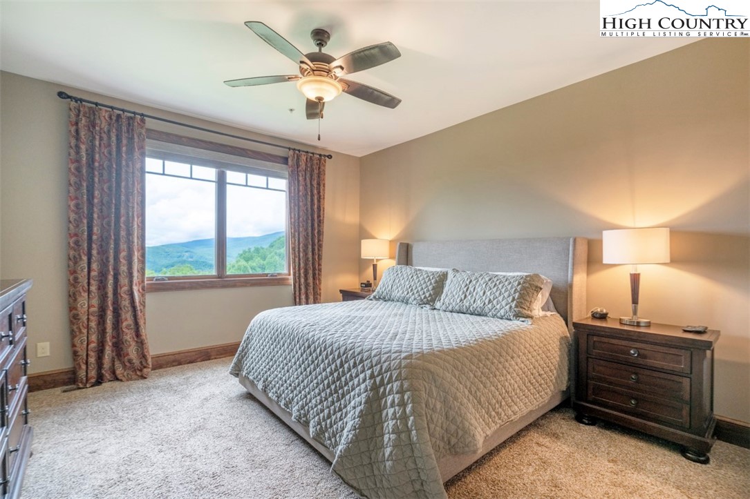 171 Falcon Trace, Unit C411 Boone, NC 28607 - Photo 24 of 46 a bedroom with a bed and a chandelier