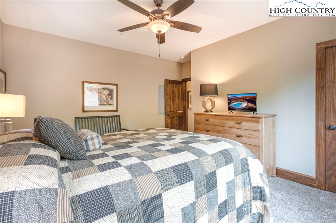 171 Falcon Trace, Unit C411 Boone, NC 28607 - Photo 32 of 46 a bedroom with a bed and a chandelier