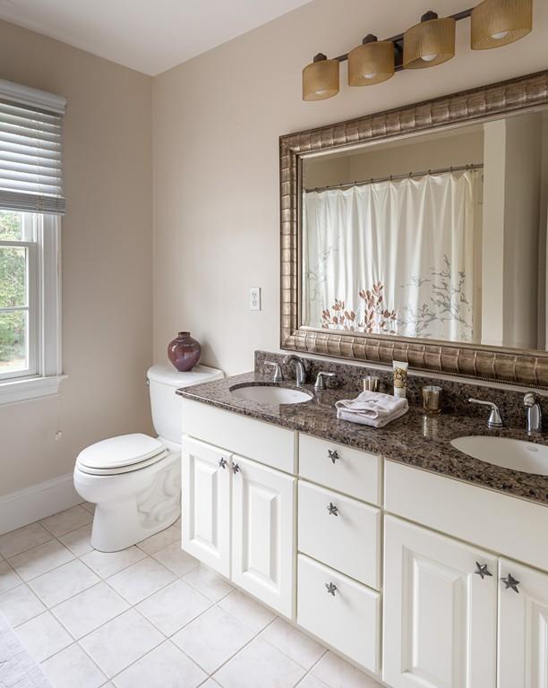 77 Hiller Road Rochester, MA 02770 - Photo 23 of 33 a bathroom with a granite countertop toilet a sink a mirror and a window