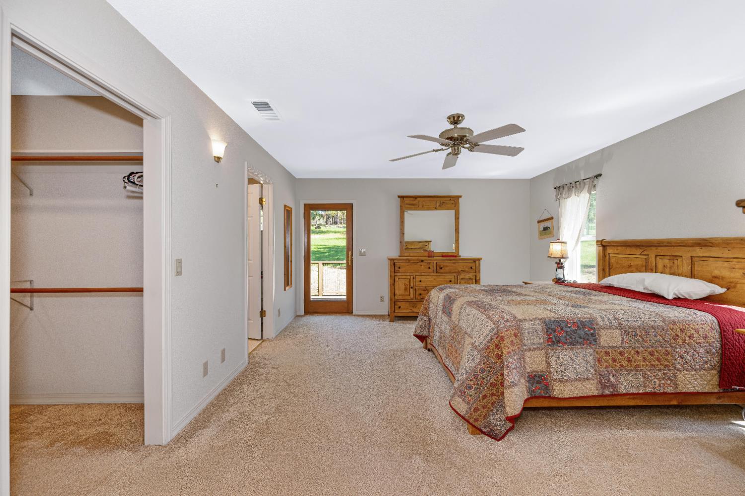 5215 Faraway Road Greenwood, CA 95635 - Photo 19 of 46 bedroom with light carpet, multiple windows, a closet, and a ceiling fan