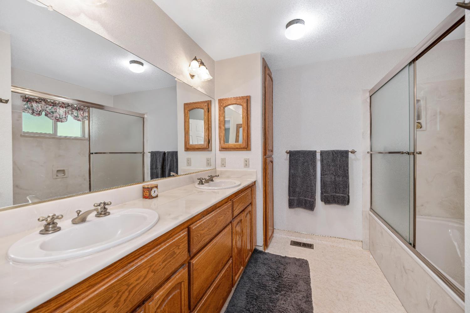 5215 Faraway Road Greenwood, CA 95635 - Photo 46 of 46 bathroom featuring double vanity and enclosed tub / shower combo