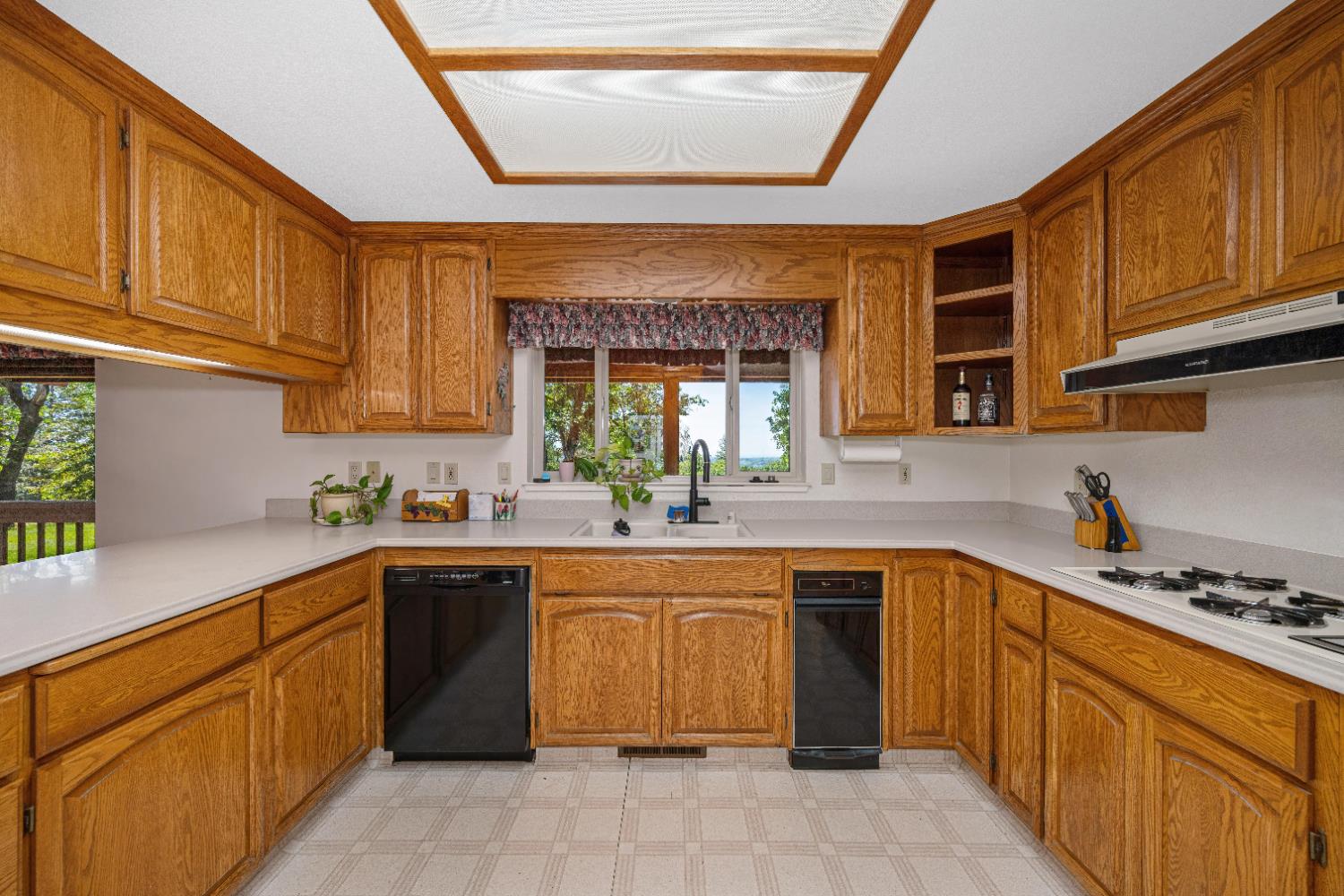 5215 Faraway Road Greenwood, CA 95635 - Photo 7 of 46 kitchen featuring wood finish cabinetry, dishwasher, light flooring, and light countertops
