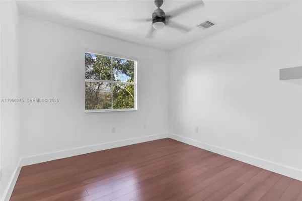 wooden floor in an empty room with a window