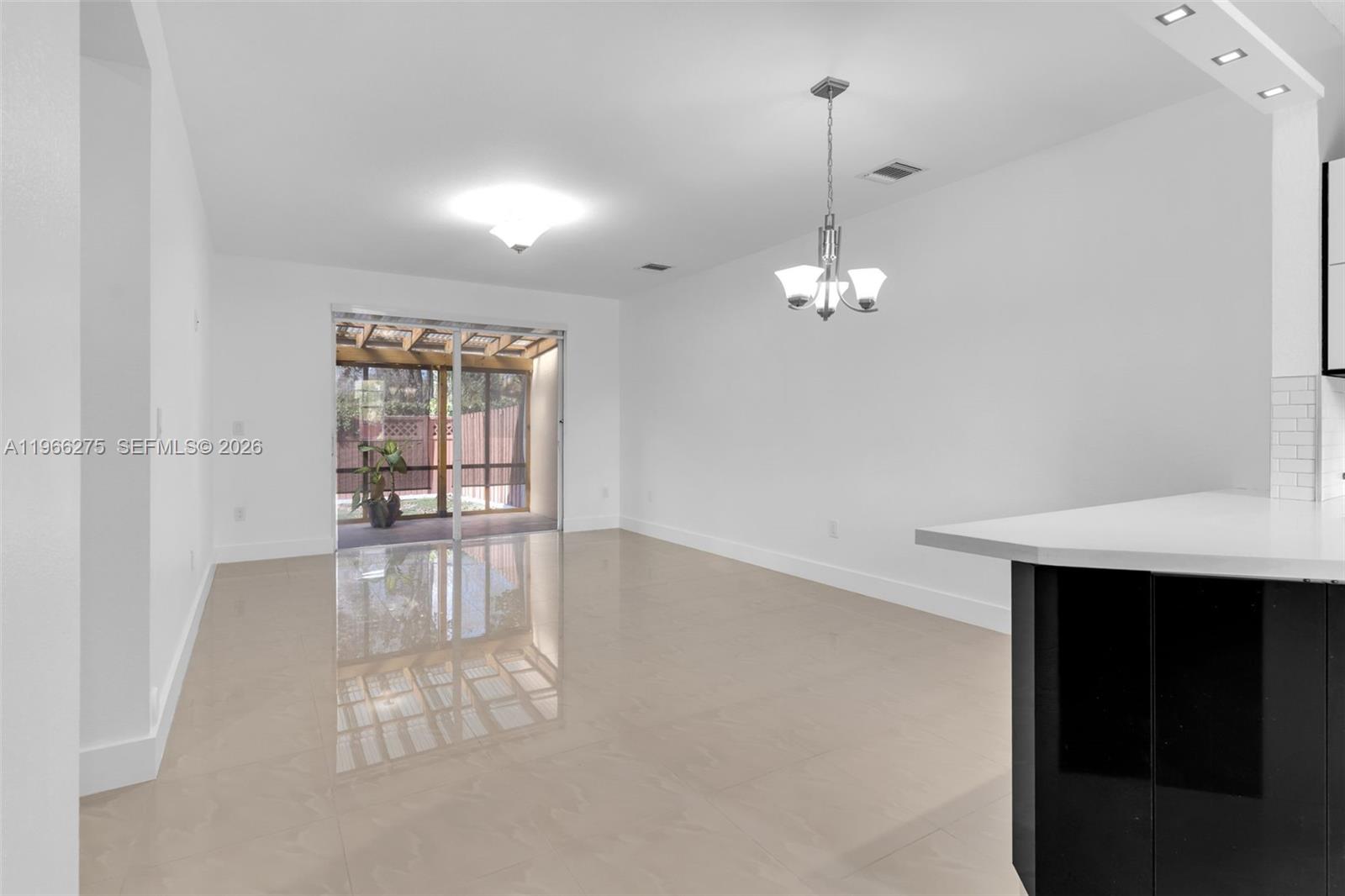 30 Southeast 6th Road Homestead, FL 33030 - Photo 8 of 34 a view of a room with wooden floor and chandelier