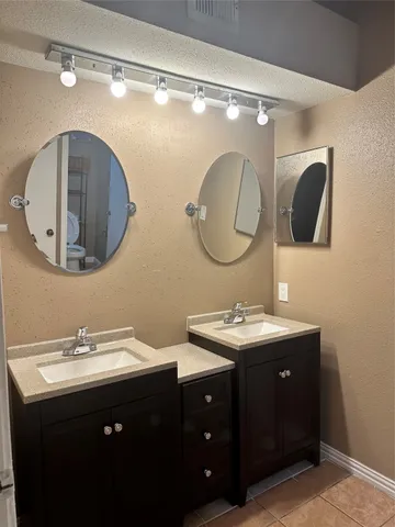 a bathroom with a double vanity sink and a mirror