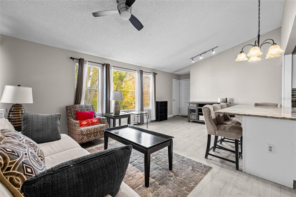 2601 Southwest Archer Road, Unit 334 Gainesville, FL 32608 - Photo 8 of 31 a living room with furniture a window and a chandelier