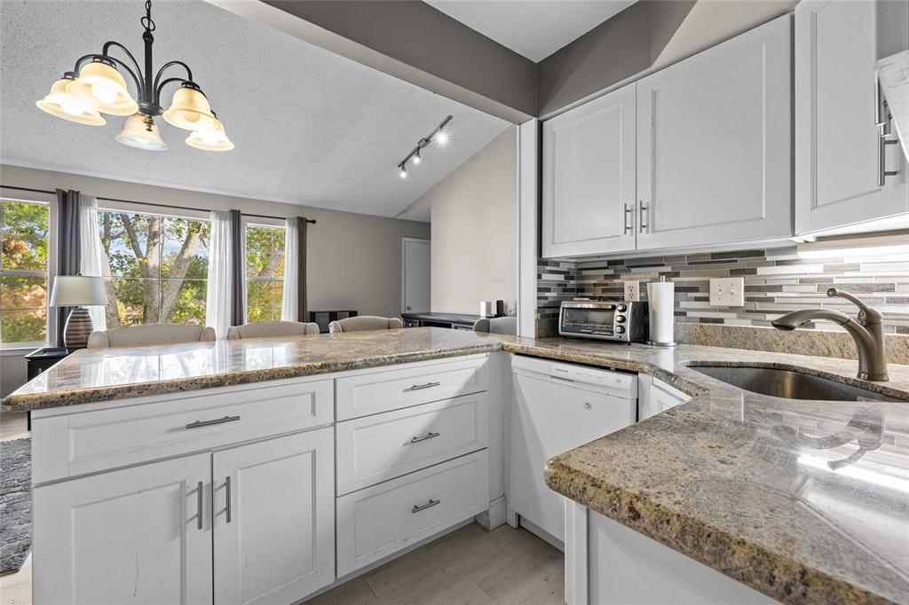 2601 Southwest Archer Road, Unit 334 Gainesville, FL 32608 - Photo 9 of 31 a kitchen with granite countertop white cabinets white stainless steel appliances and sink