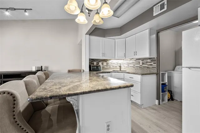 a kitchen with stainless steel appliances granite countertop a sink a stove and a refrigerator