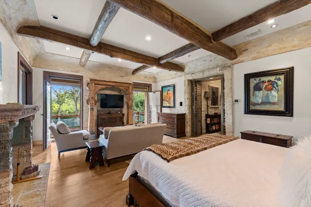 a large bedroom with bed and glass windows