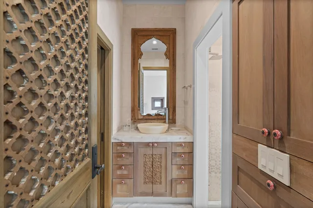 a bathroom with a granite countertop sink a mirror and a shower