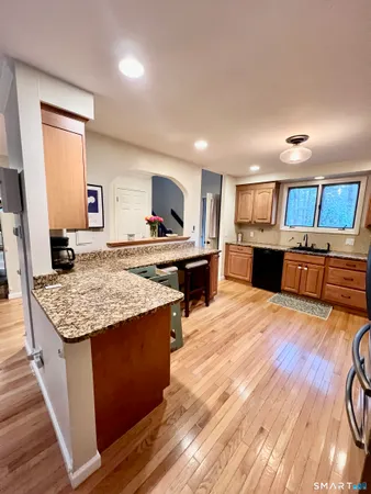 a kitchen with stainless steel appliances granite countertop a kitchen island a stove and a sink