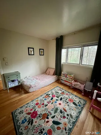 a room with a bed and a painting on the wall