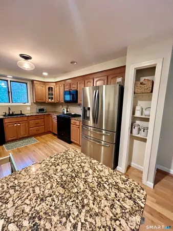 a kitchen with stainless steel appliances kitchen island granite countertop a refrigerator and a stove top oven