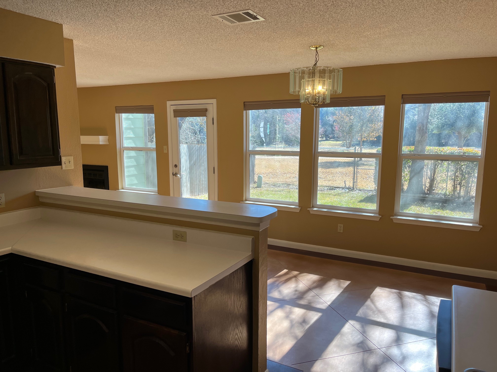 12919 Marimba Trail Austin, TX 78729 - Photo 12 of 20 Kitchen with hanging lights, light countertops, a textured ceiling, and dark tile patterned flooring