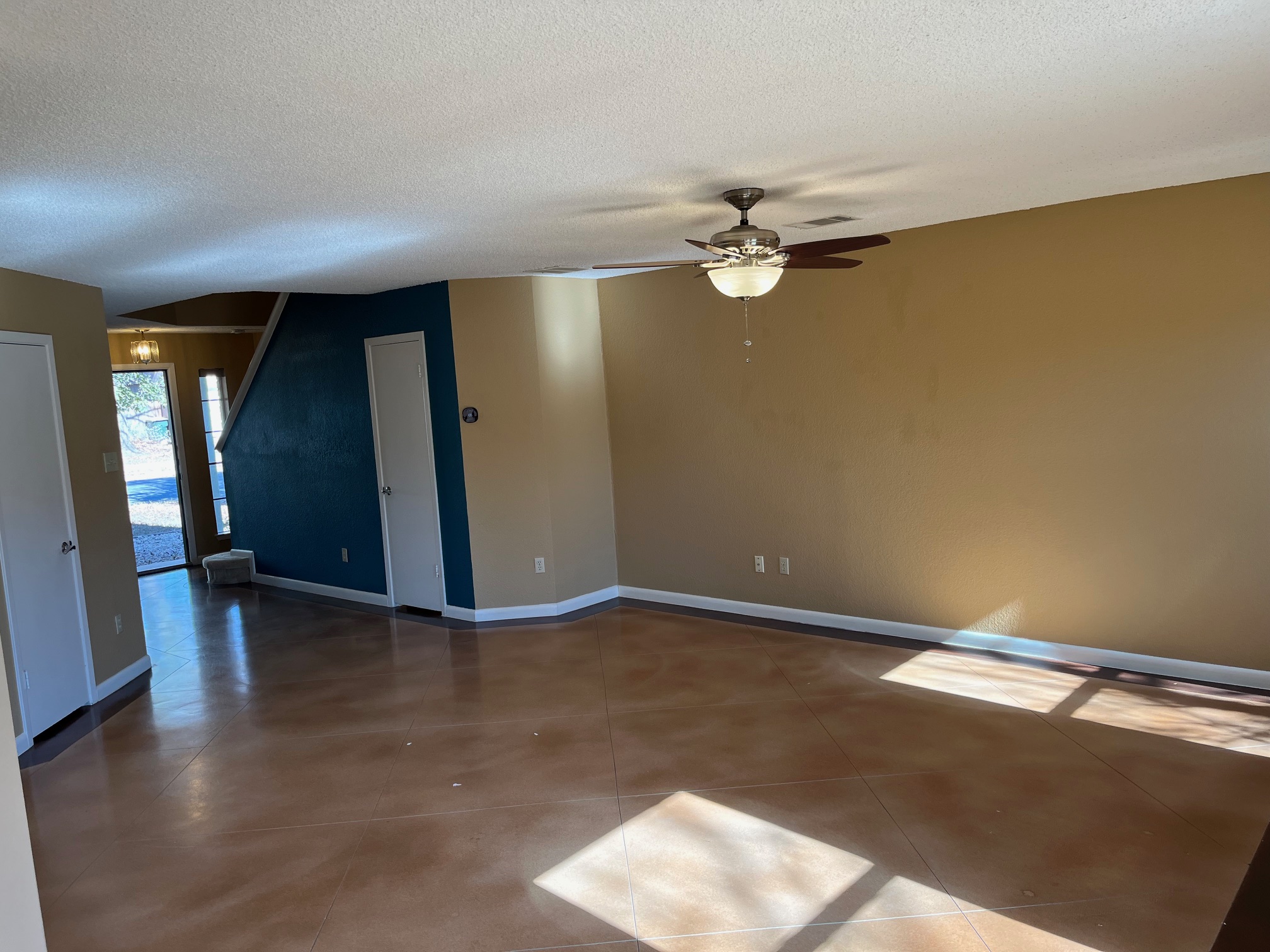 12919 Marimba Trail Austin, TX 78729 - Photo 7 of 20 Empty room with concrete floors, a ceiling fan, and a textured ceiling