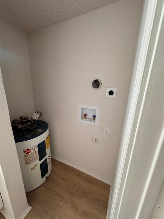 2305 Basil Drive, Unit D108 Arlington, TX 76006 - Photo 13 of 23 Washroom with wood finished floors, a textured ceiling, water heater, washer hookup, and gas dryer hookup