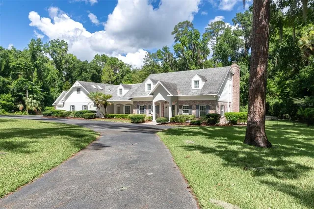 a front view of a house with a yard and potted plants