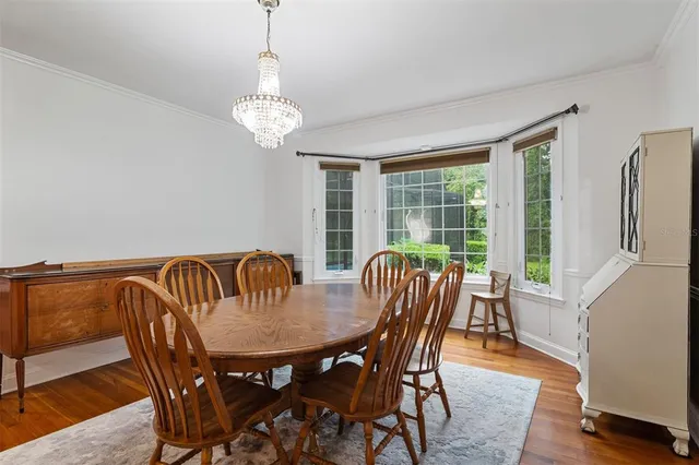 a dining room with furniture a chandelier and wooden floor