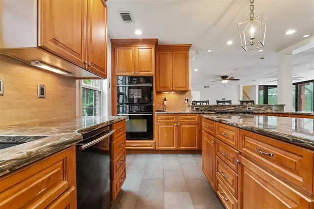 a kitchen with stainless steel appliances granite countertop wooden cabinets a refrigerator and a stove