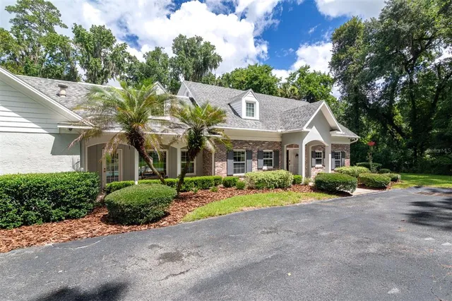 a front view of a house with a yard and trees
