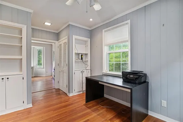 a view of an empty room with wooden floor fireplace and a window