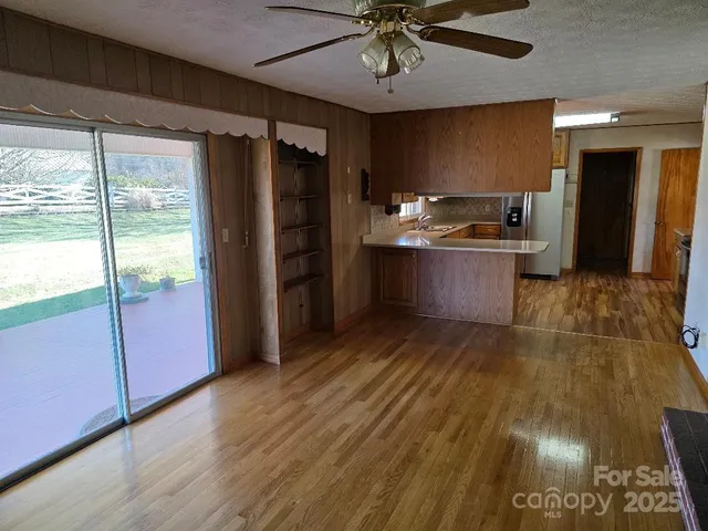 a kitchen with a refrigerator wooden floor a sink and a window