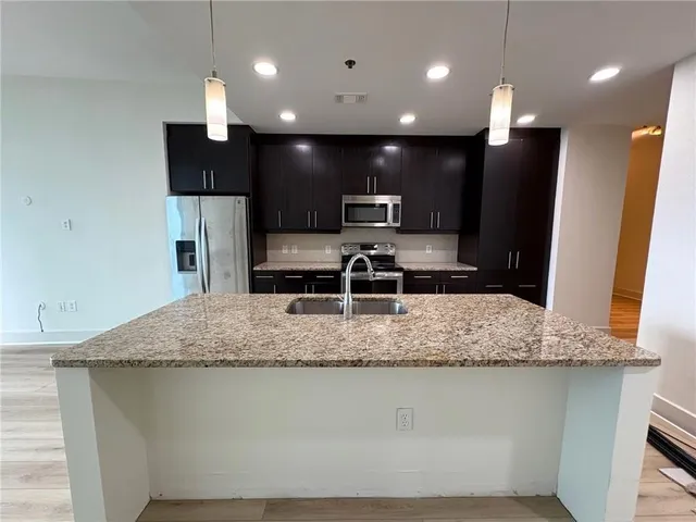 a view of kitchen with stainless steel appliances granite countertop counter space