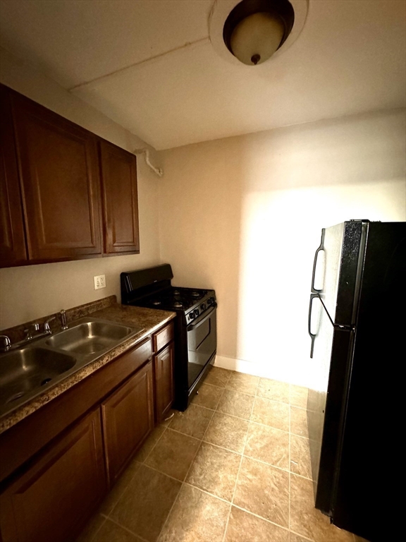 2-6 North Main Street Rochester, NH 03867 - Photo 12 of 40 a kitchen with granite countertop a refrigerator a stove and a microwave