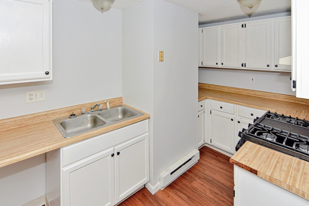 2-6 North Main Street Rochester, NH 03867 - Photo 33 of 40 a kitchen with wooden cabinets stove and sink