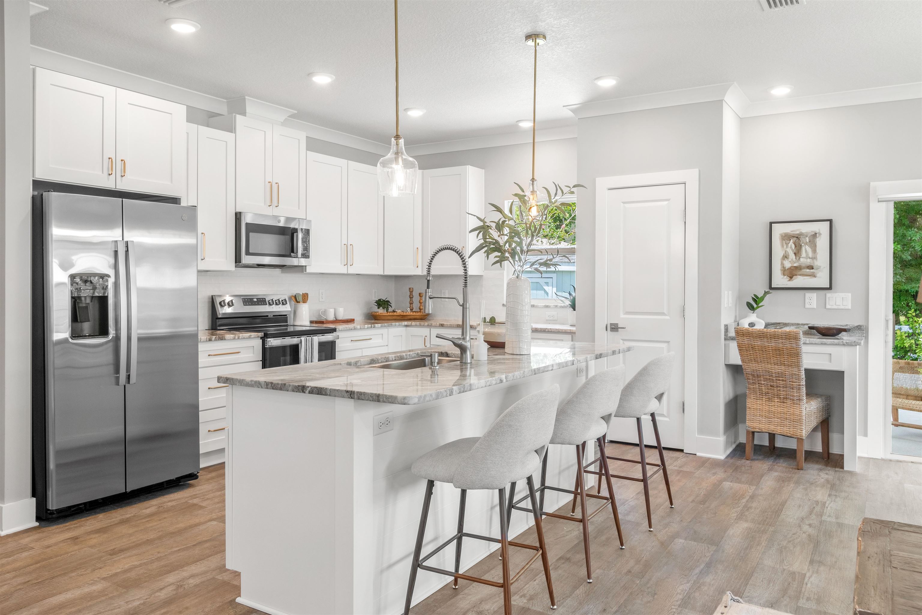 6779 Magnolia Lane St. Augustine, FL 32086 - Photo 11 of 61 a kitchen with kitchen island granite countertop stainless steel appliances a refrigerator a stove a sink a dining table and chairs with wooden floor