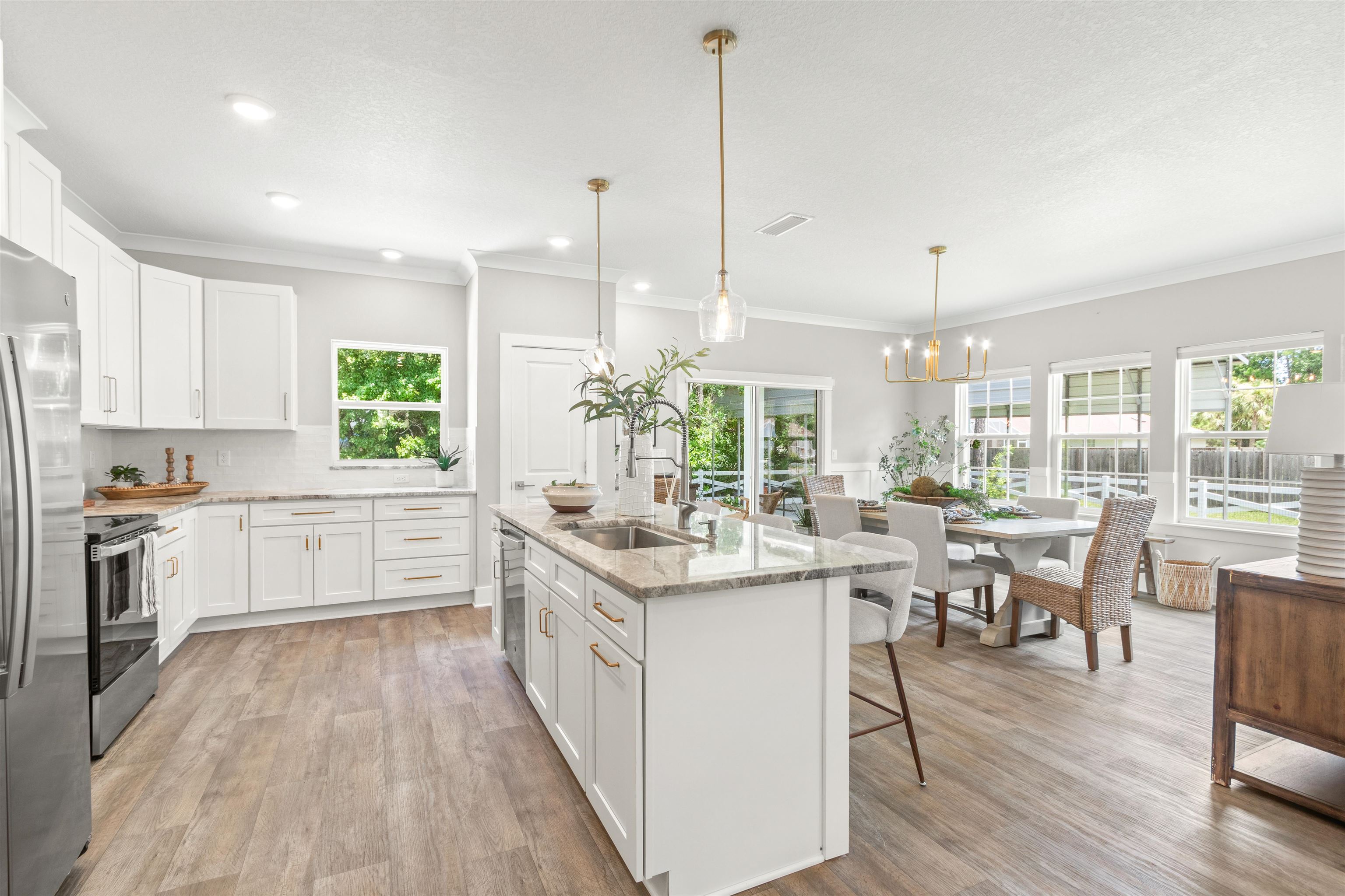 6779 Magnolia Lane St. Augustine, FL 32086 - Photo 12 of 61 a open kitchen with stainless steel appliances granite countertop a stove top oven a refrigerator a dining table and chairs with wooden floor