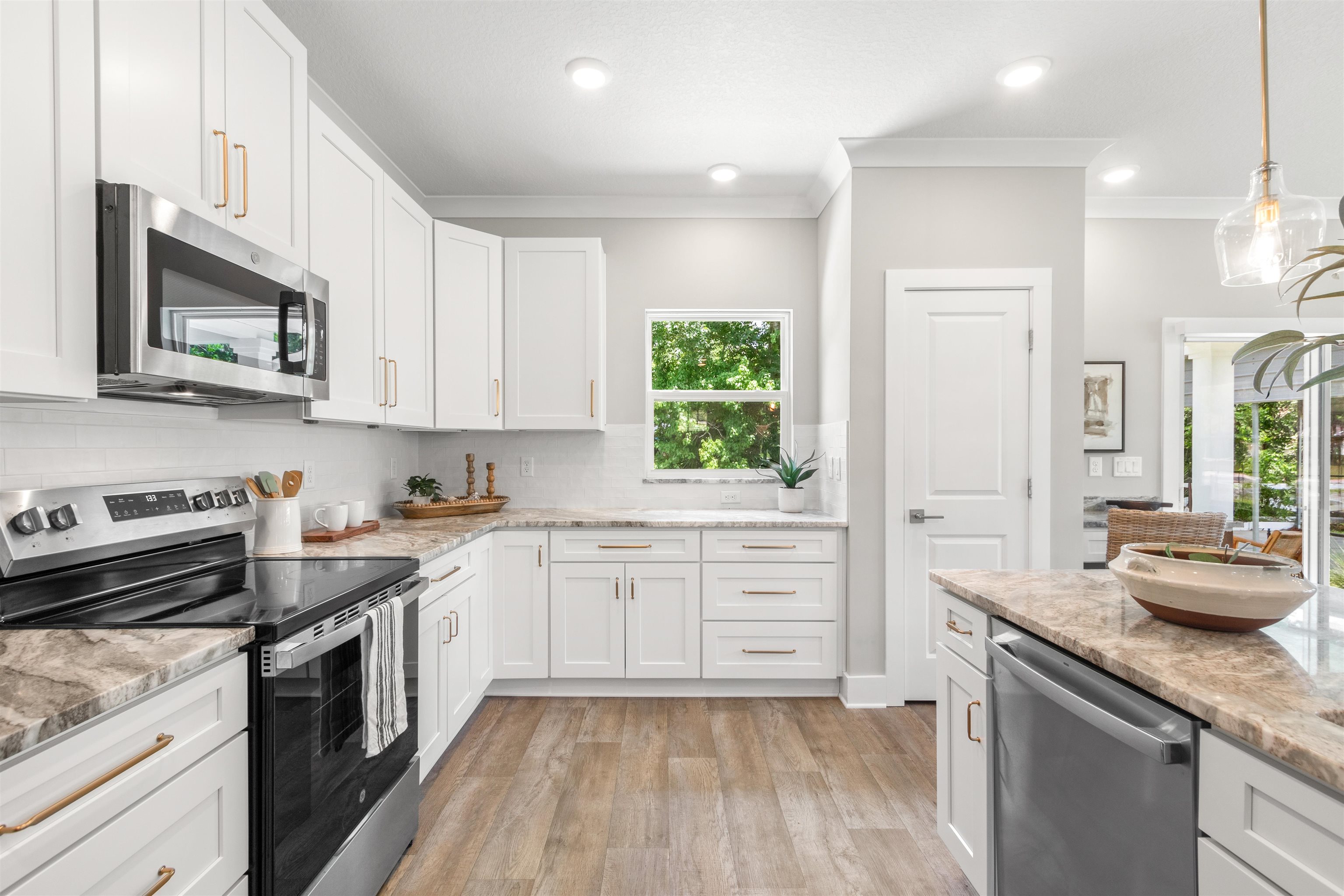 6779 Magnolia Lane St. Augustine, FL 32086 - Photo 13 of 61 a kitchen with stainless steel appliances granite countertop a stove a sink and a microwave